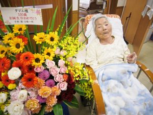 豪華な花束の前でVサイン